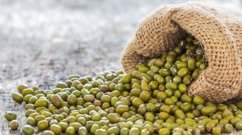 Mung beans pouring out of burlap sack