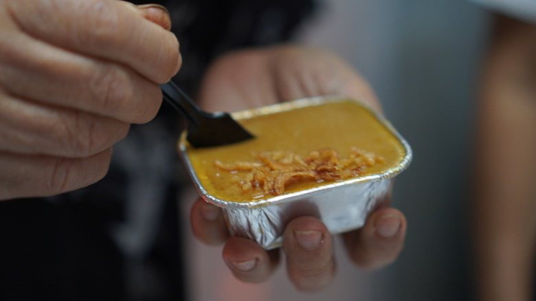 A person digging a small spoon into mung bean custard