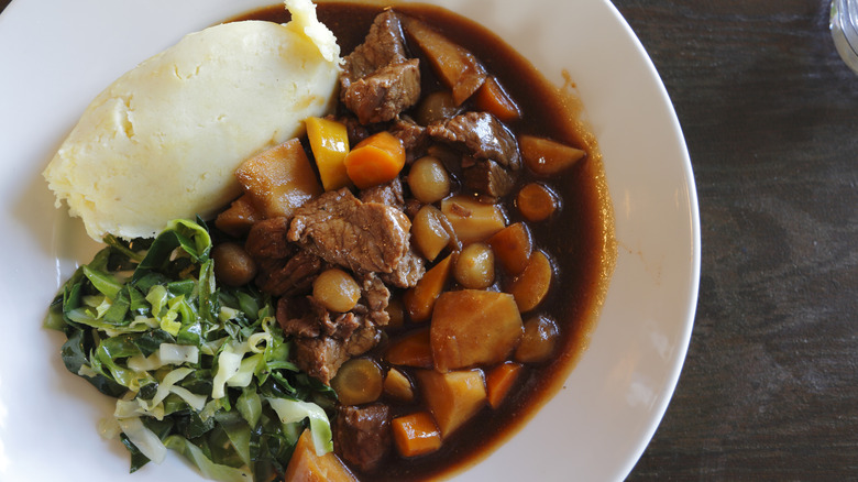 top down view of beef stew in a plate with mashed potatoes