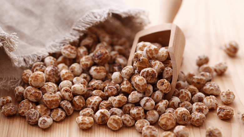 Tiger nuts gathered into a pile with a wooden scoop