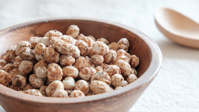 Tiger nuts gathered into a pile with a wooden scoop