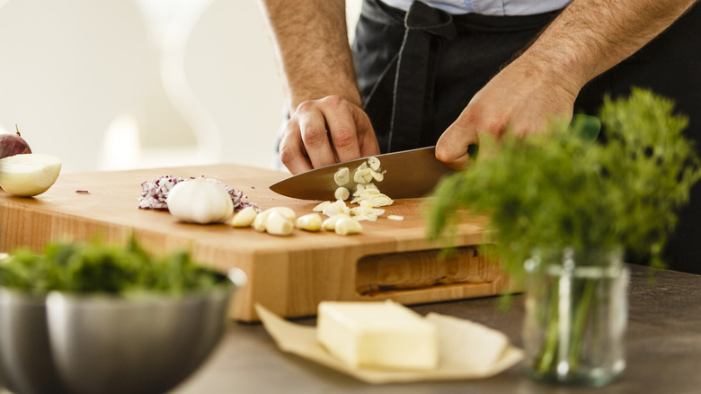 Chopping garlic and herbs on a cutting board