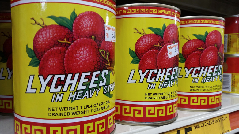 cans of lychees in syrup on shelf