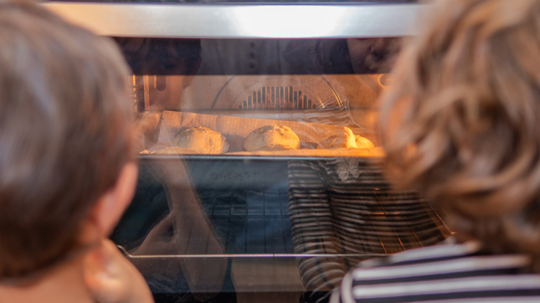 two kids watch the oven while scones rise