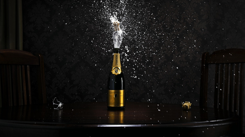 A bottle of Champagne sprays bubbles