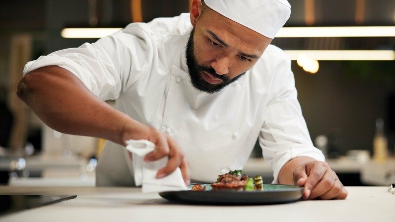 A chef preparing a plate in a restaurant kitchen