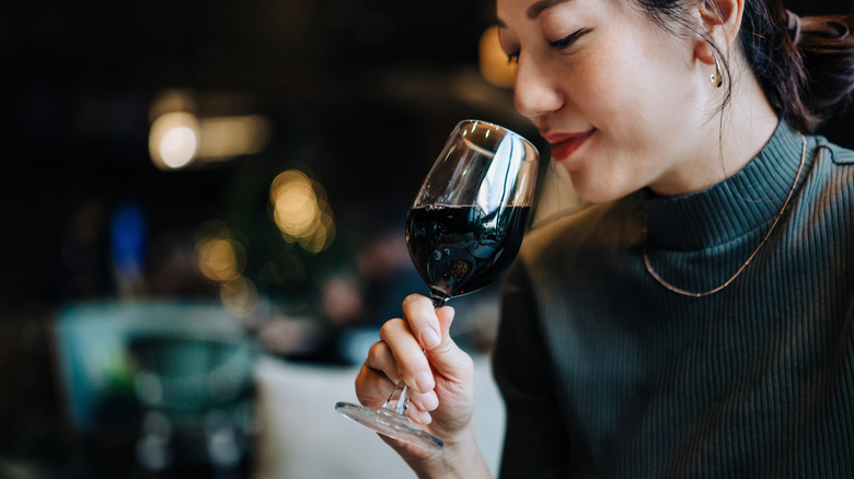 Woman smelling glass of red wine