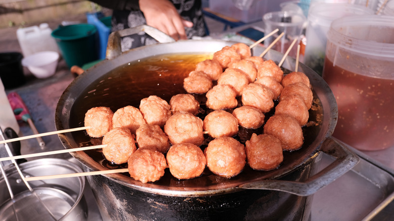 Fried fish balls in wok of oil