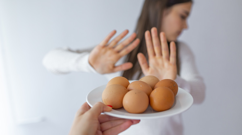 Woman refusing a plate of eggs
