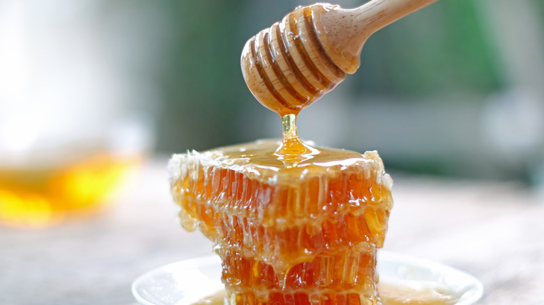 Honey being drizzled onto a honeycomb