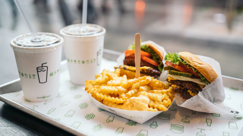 Tray of Shake Shack burgers, cheesy fries, and drinks