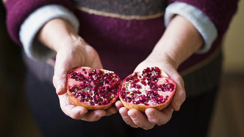 person holding pomegranate halves