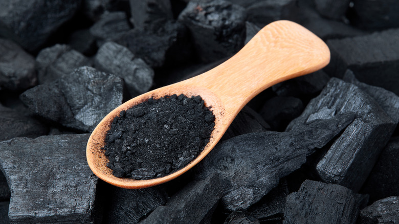 Activated charcoal in a wooden scoop