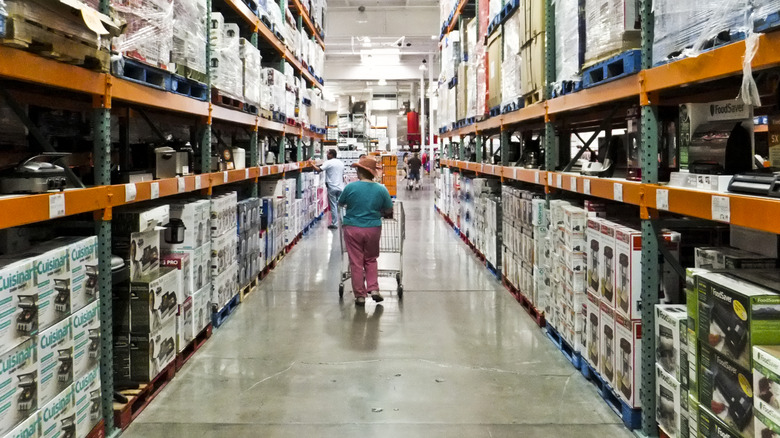 Shopper walking down Costco warehouse aisle