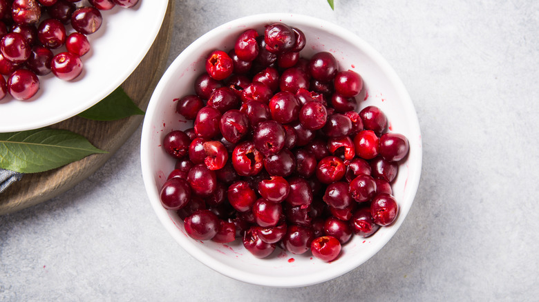 White bowl of pitted red cherries