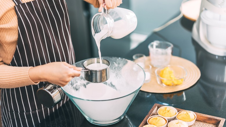 pouring milk into measuring cup