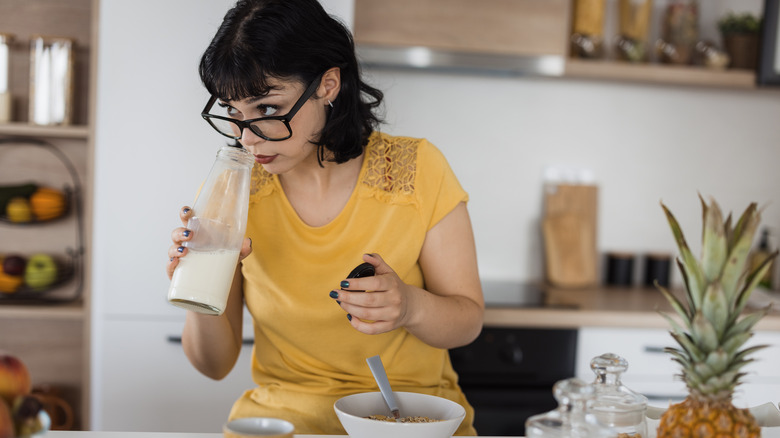 woman smelling milk in jar