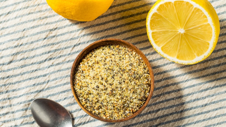 A bowl of lemon pepper season with lemons around