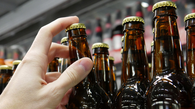 Person grabbing beer bottle store