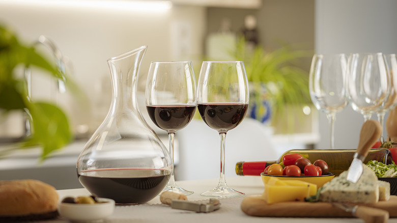 Shaft and globe decanter on a dining table with glasses of red wine