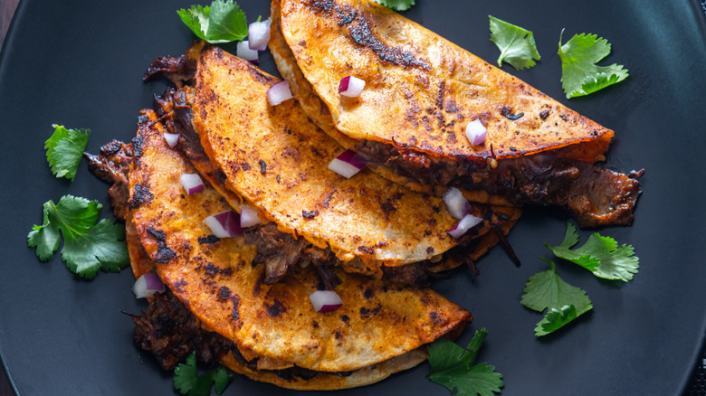 Birria tacos on dark plate