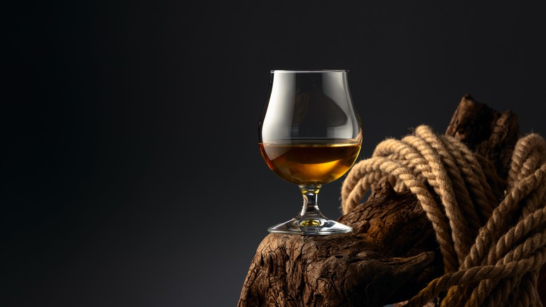 Glass of brandy sitting on rope-wrapped driftwood