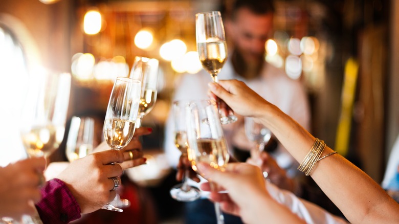 People holding Champagne glasses in a bar