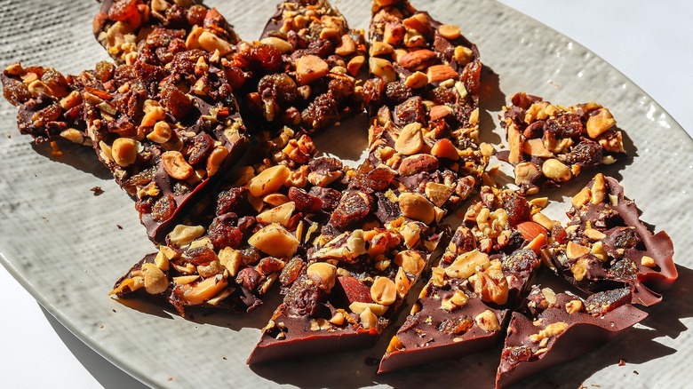 Pieces of chocolate bark topped with nuts and dried fruit