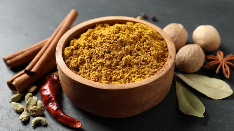 curry powder in a bowl surrounded by other spices