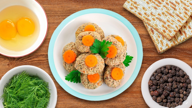 Plate of gefilte fish balls surrounded by typical ingredients