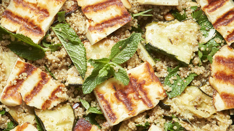 A halloumi quinoa salad garnished with fresh mint is photographed close up.