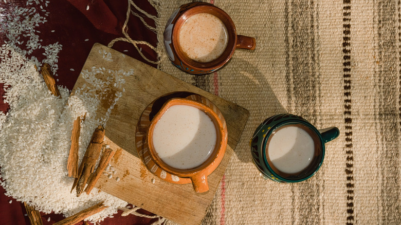 Horchata in vessels with rice, cinnamon sticks