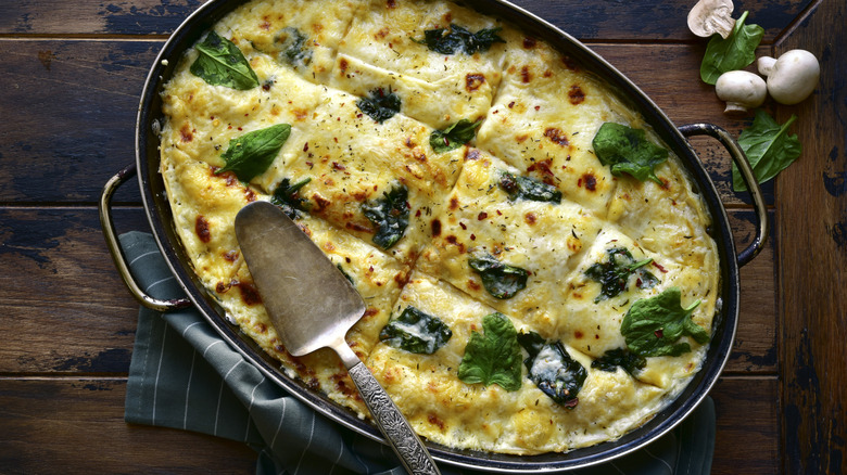 top down view of green lasagna in pan on table