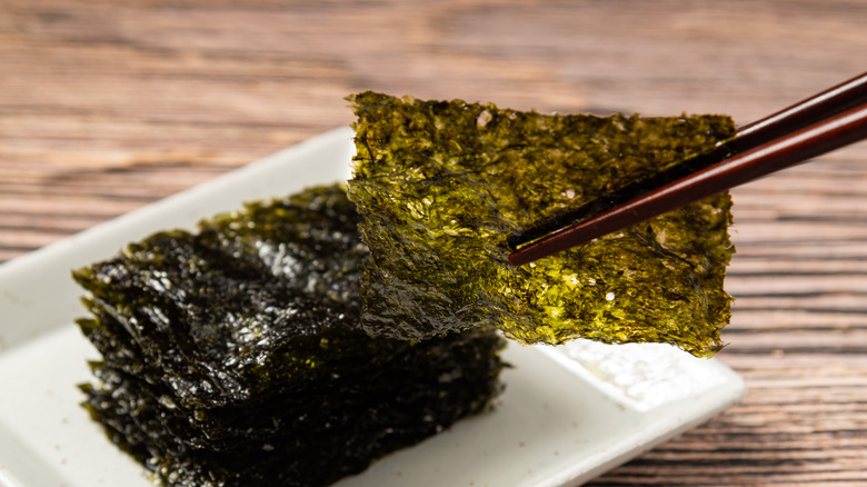 Chopsticks grabbing nori seaweed flakes