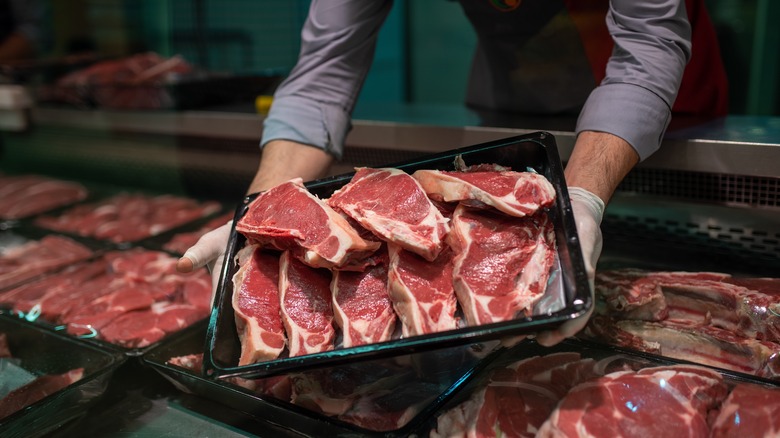 Butcher holding sheep meat