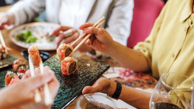 People serving each other sushi