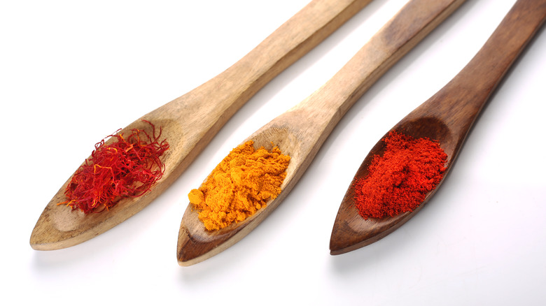Ground spices on wooden spoons