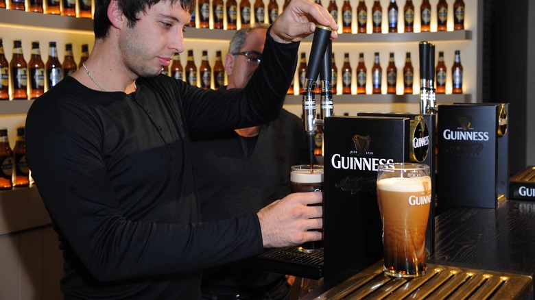 bartender pours pint of guinness