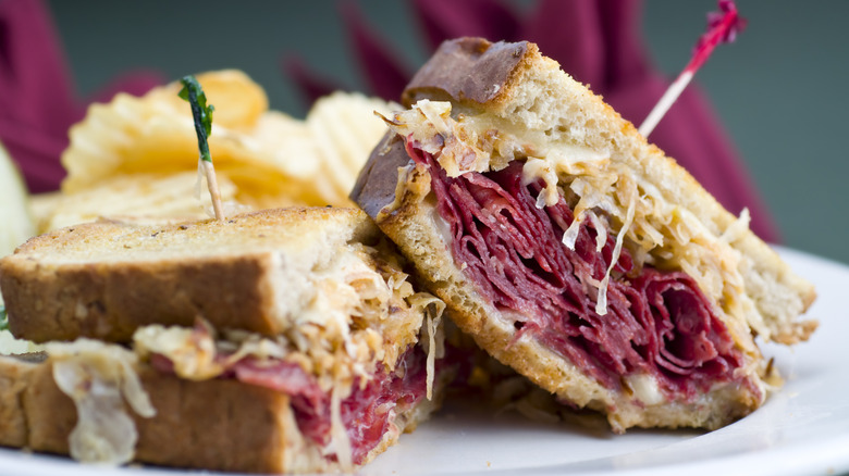 Classic Reuben sandwich on plate with ruffled potato chips in background