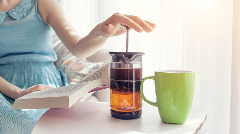 Woman's hand pushing on French press