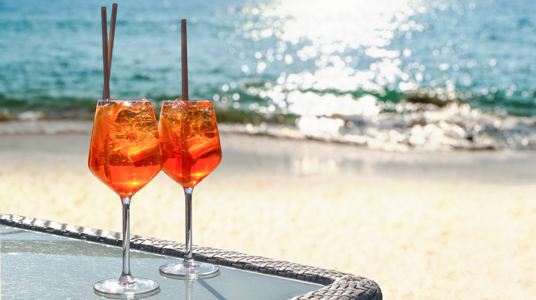 two aperol spritzes on the beach