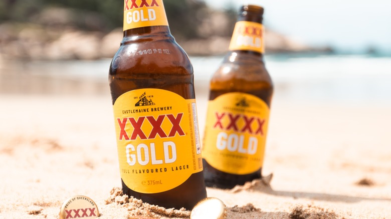 XXXX beer bottles in sand