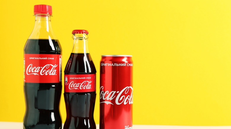 Coca Cola in a plastic bottle, glass bottle, and can