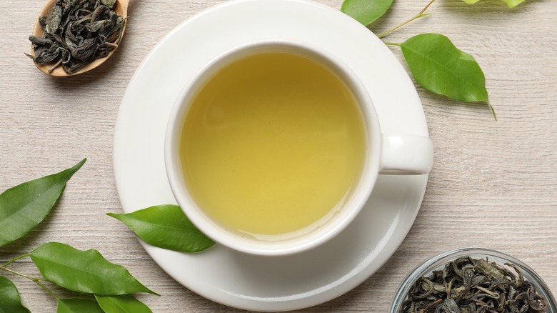 Cup of green tea in a white cup and saucer