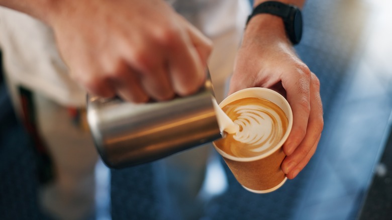 barista pouring steamed milk