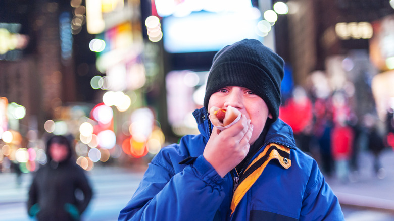 Kid eating hot dog in Times Square