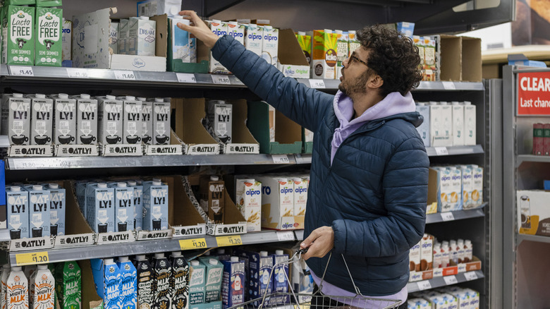 Shopper looking at different oat milks in store