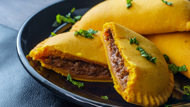 Jamaican patties cut in half on a plate.