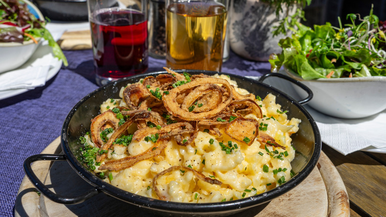 Käsespätzle served in pan next to wine and beer