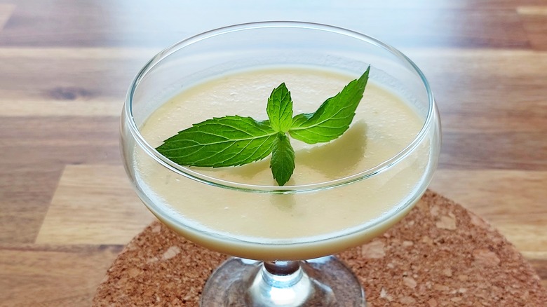 Lemon posset in a serving glass with a mint garnish